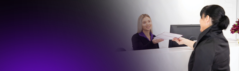 A Qscan receptionist talks to a patient